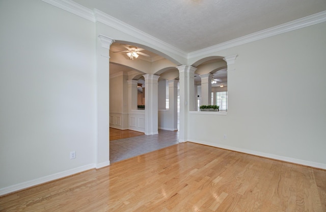 16214 Lobo Ln, Spring, TX 77379 - spare room featuring a ceiling fan, ornate columns, ornamental molding, and wood finished floors