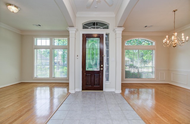 16214 Lobo Ln, Spring, TX 77379 - entryway with crown molding, ornate columns, light wood finished floors, a chandelier, and a ceiling fan