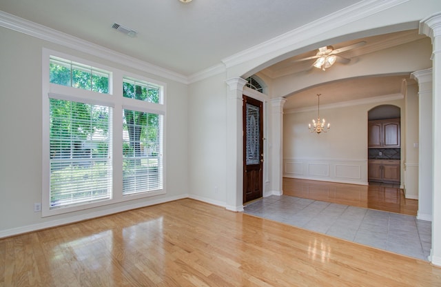 16214 Lobo Ln, Spring, TX 77379 - spare room featuring ornate columns, arched walkways, wood finished floors, a ceiling fan, and crown molding