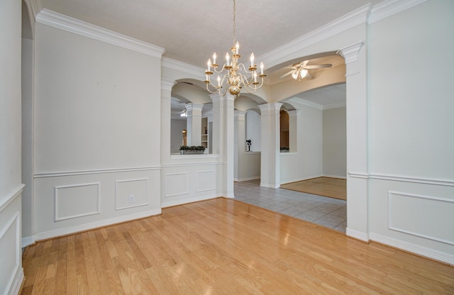 16214 Lobo Ln, Spring, TX 77379 - unfurnished dining area with ceiling fan, arched walkways, crown molding, a decorative wall, and decorative columns
