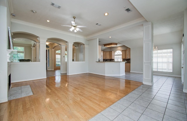 16214 Lobo Ln, Spring, TX 77379 - unfurnished living room featuring decorative columns, ceiling fan, ornamental molding, recessed lighting, and light tile patterned floors