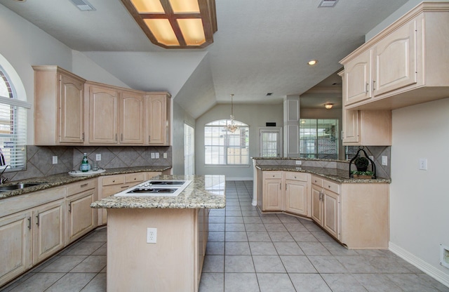16214 Lobo Ln, Spring, TX 77379 - kitchen with light brown cabinets, white electric cooktop, tasteful backsplash, light stone countertops, and lofted ceiling