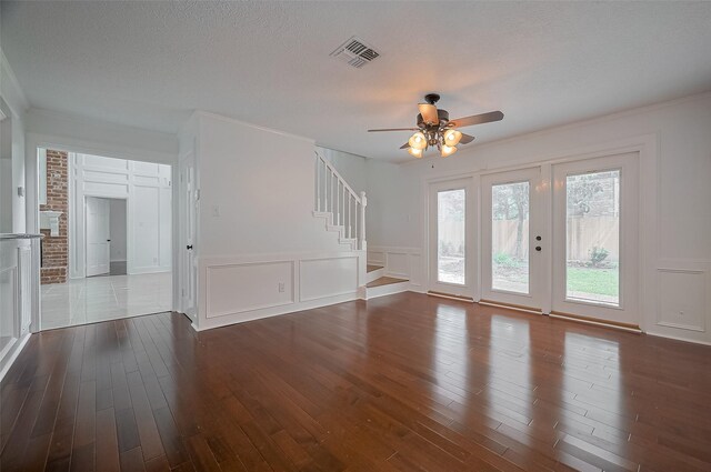 9411 Fenchurch Dr, Spring, TX 77379 - unfurnished living room with a decorative wall, a ceiling fan, dark wood-style floors, stairway, and crown molding