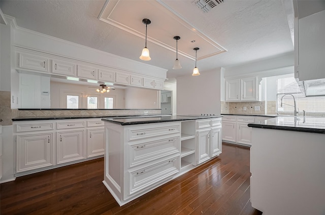 9411 Fenchurch Dr, Spring, TX 77379 - kitchen featuring white cabinets, dark countertops, ceiling fan, decorative backsplash, and dark wood-style floors