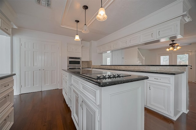 9411 Fenchurch Dr, Spring, TX 77379 - kitchen with dark wood-type flooring, a kitchen island, white cabinets, a peninsula, and crown molding