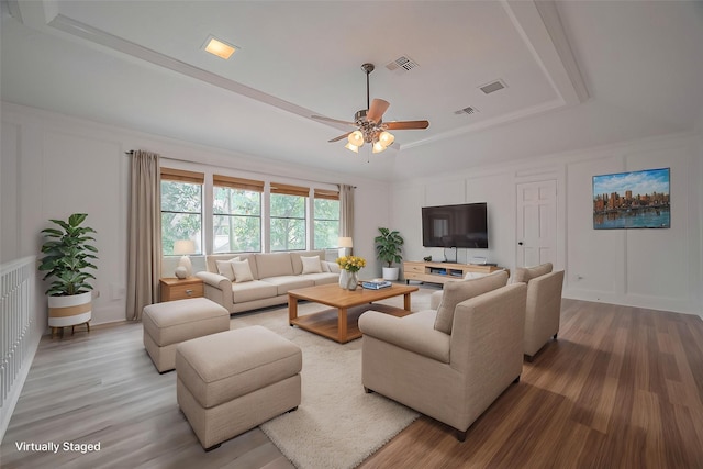 9411 Fenchurch Dr, Spring, TX 77379 - living area with a raised ceiling, a ceiling fan, light wood-style flooring, and a decorative wall