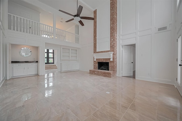 9411 Fenchurch Dr, Spring, TX 77379 - unfurnished living room with a high ceiling, ceiling fan, a decorative wall, a fireplace, and light marble finish floors