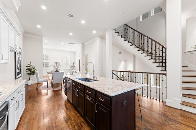 1705 Upland Lks, Houston, TX 77043 - kitchen featuring open floor plan, a kitchen breakfast bar, white cabinetry, stainless steel dishwasher, and an island with sink