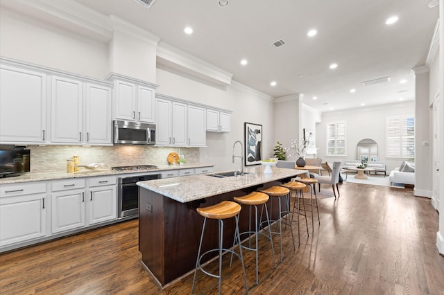 1705 Upland Lks, Houston, TX 77043 - kitchen featuring stainless steel appliances, ornamental molding, decorative backsplash, an island with sink, and open floor plan
