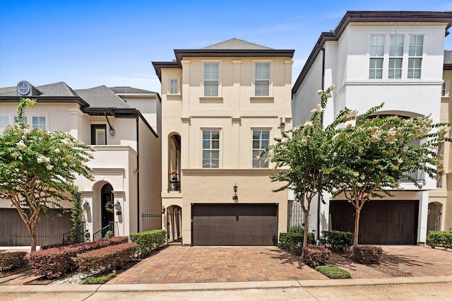 1705 Upland Lks, Houston, TX 77043 - view of front facade featuring an attached garage, stucco siding, and decorative driveway