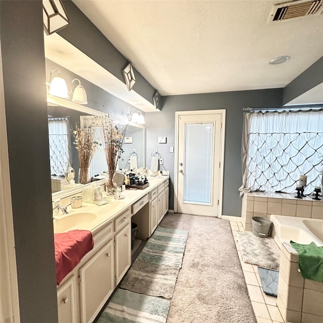 12006 Mill Trail Ln, Houston, TX 77070 - bathroom with double vanity, a tub to relax in, tile patterned floors, and a textured ceiling