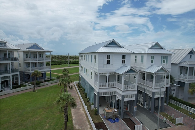 2602 E Seaside Dr, Galveston, TX 77550 - back of house with a metal roof, decorative driveway, a carport, and a yard