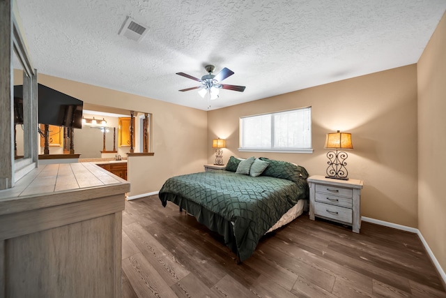 13202 N Decker Dr, Magnolia, TX 77355 - bedroom with dark wood-style floors, a textured ceiling, ceiling fan, and ensuite bath