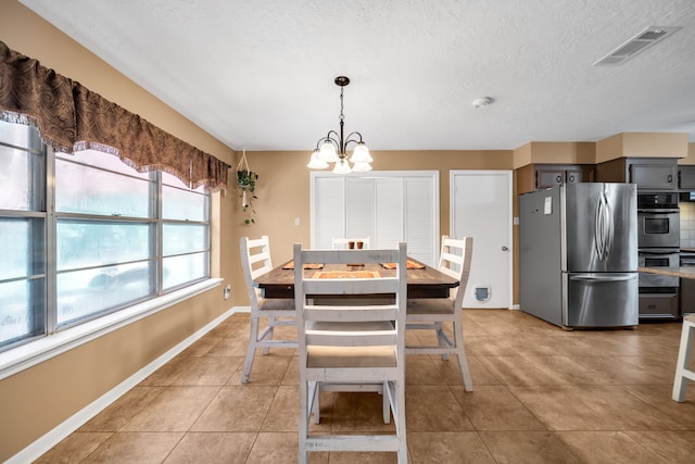 13202 N Decker Dr, Magnolia, TX 77355 - dining space with a chandelier, light tile patterned floors, and a textured ceiling
