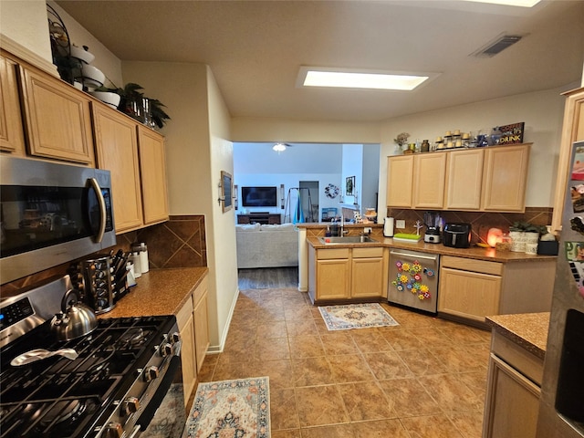 15506 Fir Woods Ln, Cypress, TX 77429 - kitchen featuring stainless steel appliances, light brown cabinets, decorative backsplash, a peninsula, and open floor plan