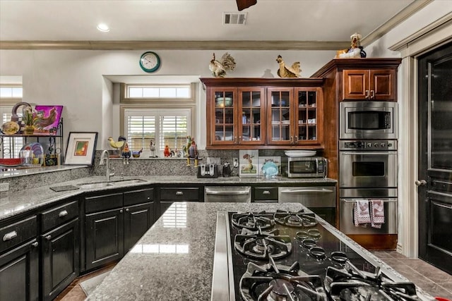 3039 Bayshore Dr, Bacliff, TX 77518 - kitchen featuring stainless steel appliances, light stone counters, glass insert cabinets, a warming drawer, and ornamental molding