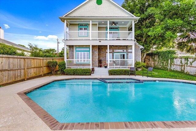 3039 Bayshore Dr, Bacliff, TX 77518 - back of house featuring ceiling fan, a fenced backyard, stone siding, and a pool with connected hot tub