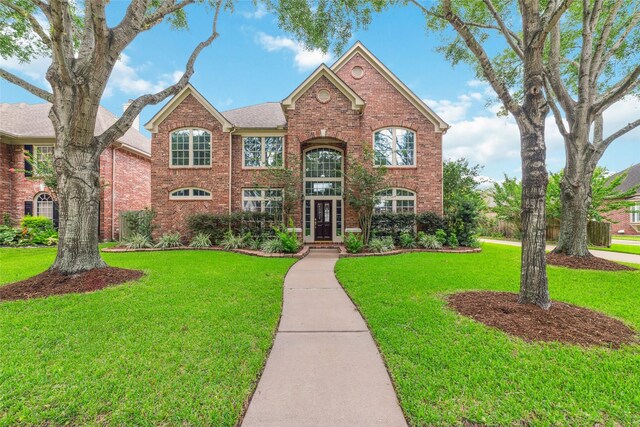 1915 Stormcroft Cir, Katy, TX 77450 - traditional-style house featuring brick siding and a front lawn