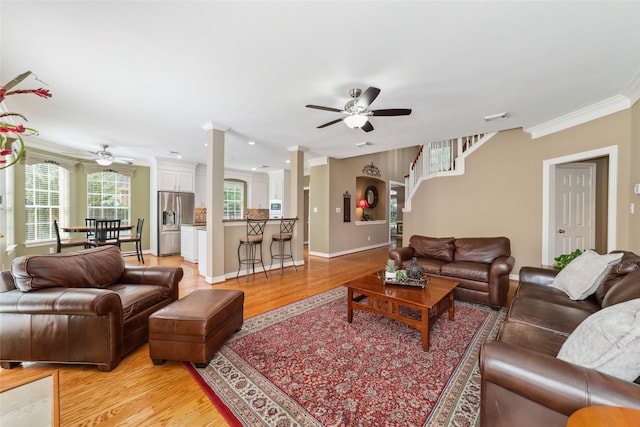 1915 Stormcroft Cir, Katy, TX 77450 - living room featuring ceiling fan, crown molding, light wood-style floors, and decorative columns