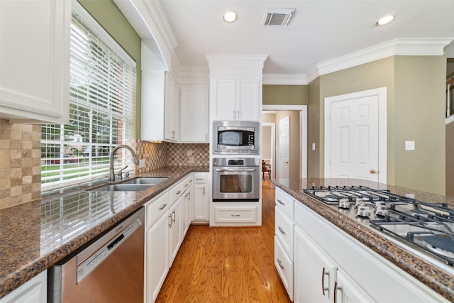 1915 Stormcroft Cir, Katy, TX 77450 - kitchen featuring appliances with stainless steel finishes, light wood-style floors, white cabinetry, crown molding, and recessed lighting