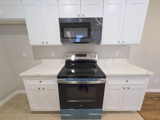 8100 Cambridge St Unit 99, Houston, TX 77054 - kitchen with stainless steel electric stove, white cabinets, and light stone counters