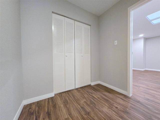 8100 Cambridge St Unit 99, Houston, TX 77054 - unfurnished bedroom with dark wood finished floors, a closet, and a skylight