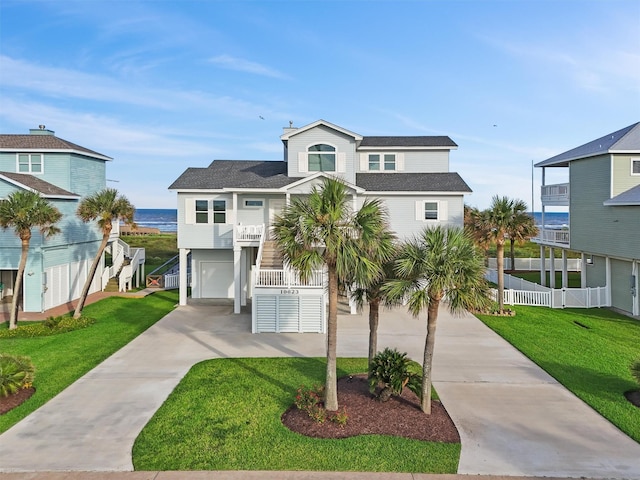 19623 Shores Dr, Galveston, TX 77554 - coastal home featuring driveway, an attached garage, stairs, a balcony, and a shingled roof