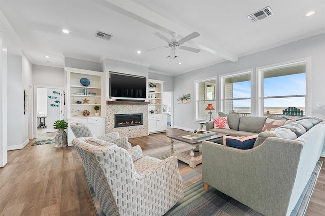 19623 Shores Dr, Galveston, TX 77554 - living room featuring a ceiling fan, a glass covered fireplace, recessed lighting, crown molding, and wood finished floors