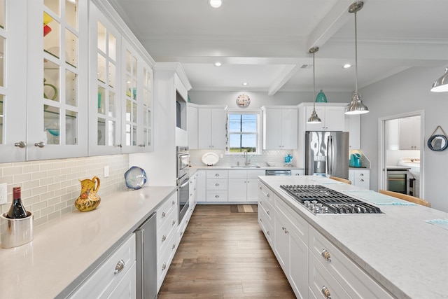 19623 Shores Dr, Galveston, TX 77554 - kitchen featuring appliances with stainless steel finishes, white cabinets, light countertops, crown molding, and beamed ceiling