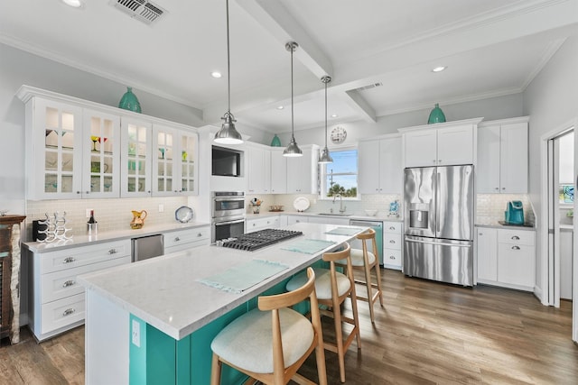 19623 Shores Dr, Galveston, TX 77554 - kitchen featuring appliances with stainless steel finishes, a kitchen island, white cabinets, crown molding, and beam ceiling