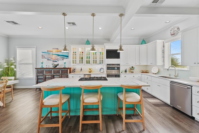 19623 Shores Dr, Galveston, TX 77554 - kitchen featuring stainless steel appliances, ornamental molding, tasteful backsplash, white cabinetry, and a center island