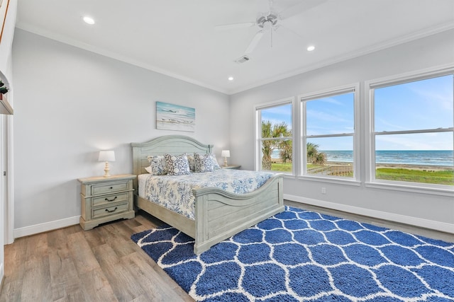 19623 Shores Dr, Galveston, TX 77554 - bedroom featuring crown molding, wood finished floors, recessed lighting, ceiling fan, and a water view