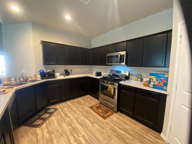 6138 Lillybelle St, Katy, TX 77449 - kitchen featuring stainless steel appliances, light wood finished floors, light countertops, and dark cabinetry