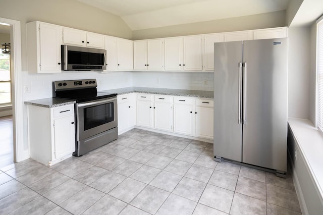 238 Almond Dr, Lake Jackson, TX 77566 - kitchen featuring stainless steel appliances, vaulted ceiling, tasteful backsplash, stone countertops, and light tile patterned floors