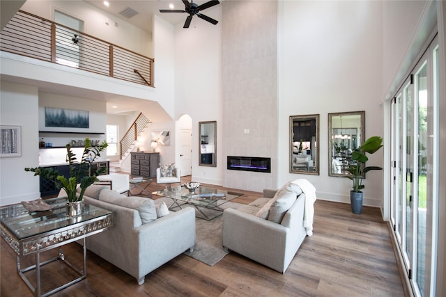 3314 Arbor St, Houston, TX 77004 - living area featuring a high ceiling, a fireplace, stairs, wood finished floors, and a ceiling fan