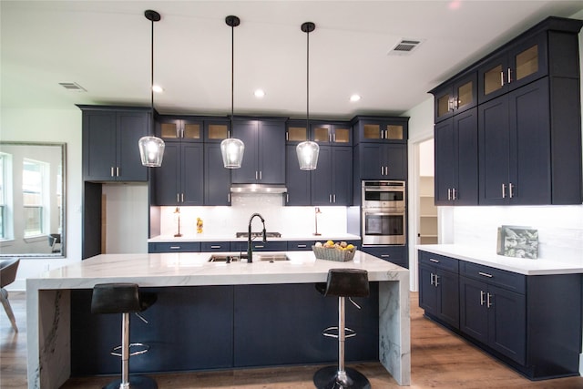 3314 Arbor St, Houston, TX 77004 - kitchen featuring double oven, backsplash, wood finished floors, under cabinet range hood, and recessed lighting
