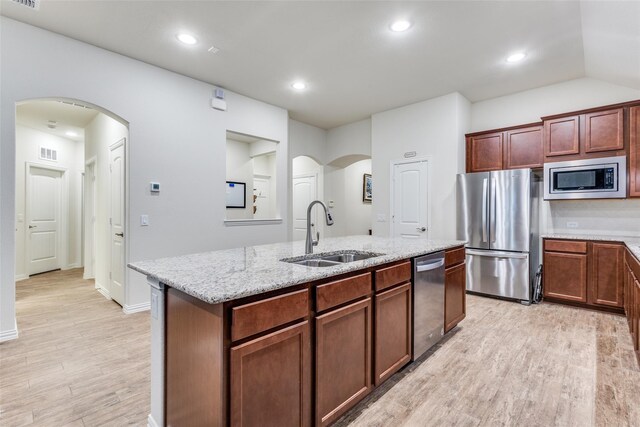 2821 Redbud Ln, Melissa, TX 75454 - kitchen with appliances with stainless steel finishes, light wood-type flooring, an island with sink, light stone countertops, and recessed lighting