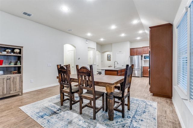2821 Redbud Ln, Melissa, TX 75454 - dining area featuring arched walkways, light wood finished floors, and recessed lighting