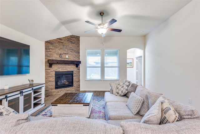 2821 Redbud Ln, Melissa, TX 75454 - living room with a ceiling fan, arched walkways, wood finished floors, a stone fireplace, and vaulted ceiling