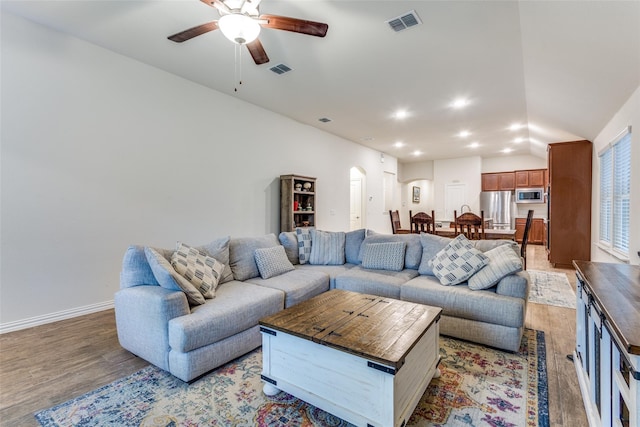 2821 Redbud Ln, Melissa, TX 75454 - living area with arched walkways, a ceiling fan, light wood-type flooring, recessed lighting, and vaulted ceiling