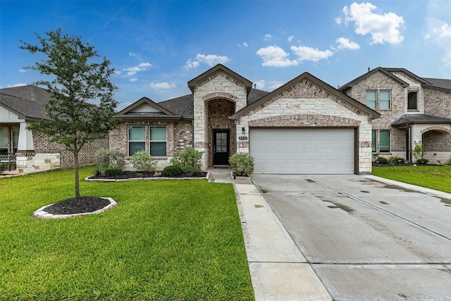 5311 Latigo Ct, Alvin, TX 77511 - view of front of property featuring an attached garage, concrete driveway, a front yard, and stone siding