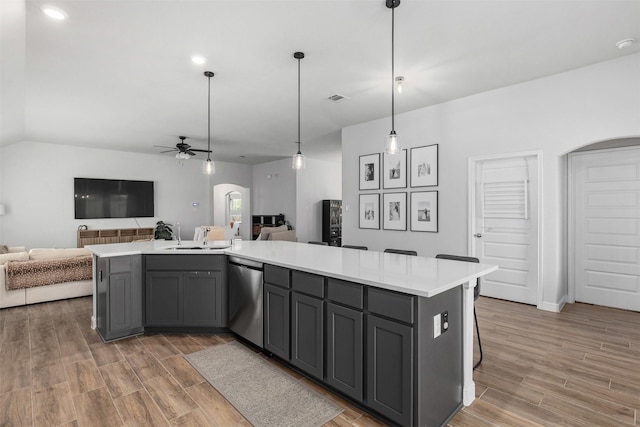 5311 Latigo Ct, Alvin, TX 77511 - kitchen featuring arched walkways, stainless steel dishwasher, open floor plan, gray cabinets, and lofted ceiling