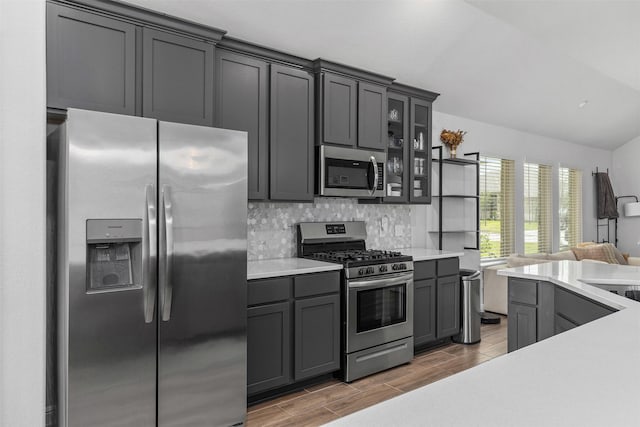 5311 Latigo Ct, Alvin, TX 77511 - kitchen featuring stainless steel appliances, open floor plan, backsplash, light countertops, and glass insert cabinets