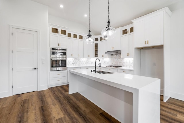 3312 Arbor St, Houston, TX 77004 - kitchen with appliances with stainless steel finishes, decorative backsplash, a center island with sink, dark wood finished floors, and light countertops