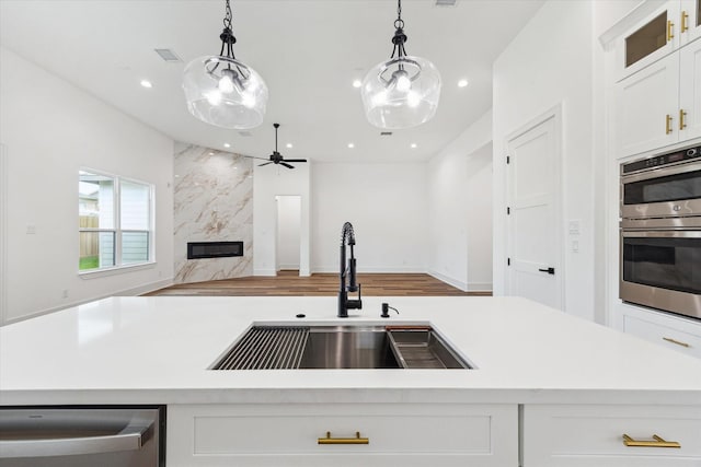 3312 Arbor St, Houston, TX 77004 - kitchen with stainless steel appliances, open floor plan, light countertops, white cabinetry, and ceiling fan