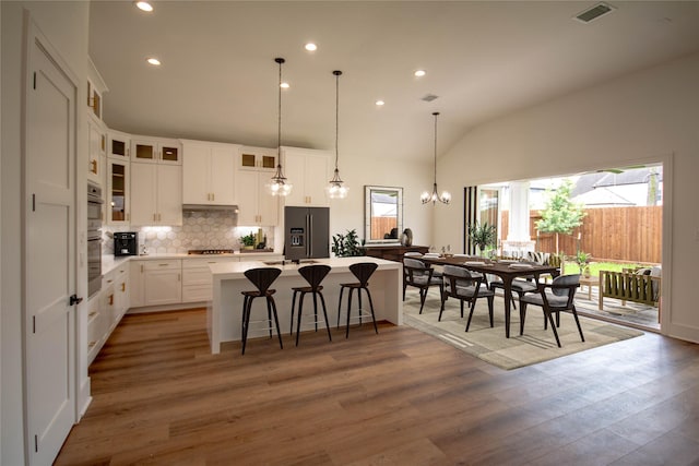 3312 Arbor St, Houston, TX 77004 - kitchen featuring a center island, a chandelier, fridge with ice dispenser, backsplash, and light wood finished floors