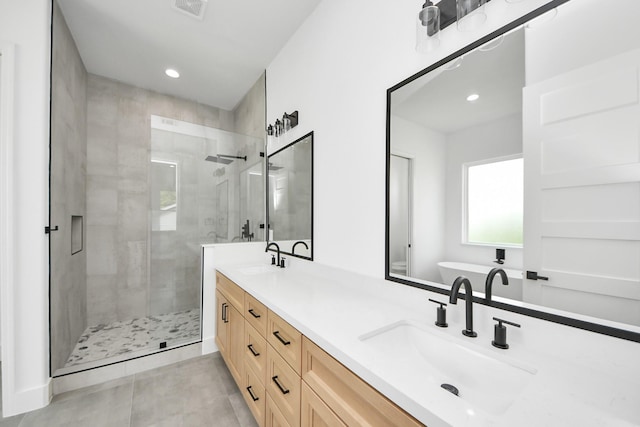 1913 W St, Houston, TX 77026 - full bathroom with a shower stall, double vanity, tile patterned floors, a freestanding bath, and recessed lighting
