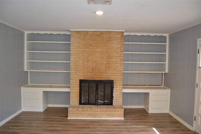 101 Summit Dr, Conroe, TX 77303 - unfurnished living room with built in study area, crown molding, wood finished floors, built in shelves, and a fireplace