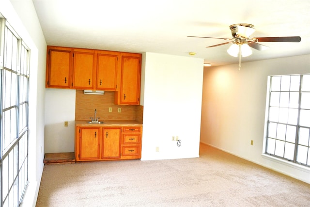 101 Summit Dr, Conroe, TX 77303 - kitchen with ceiling fan, brown cabinetry, light countertops, light carpet, and tasteful backsplash