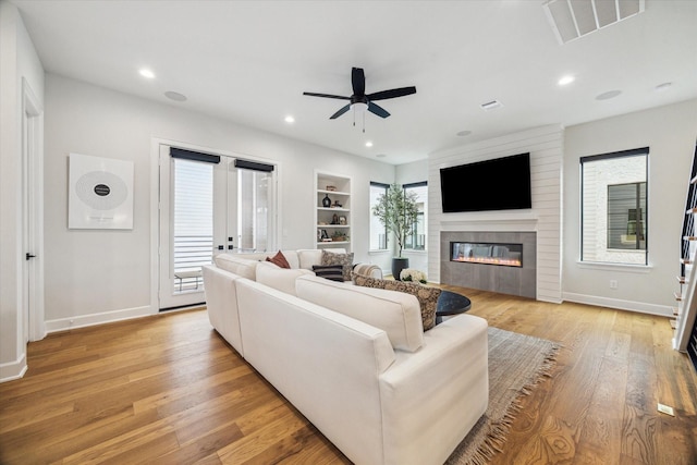 824 Wakefield Dr Unit A, Houston, TX 77018 - living room with a ceiling fan, a large fireplace, light wood-style floors, built in shelves, and recessed lighting